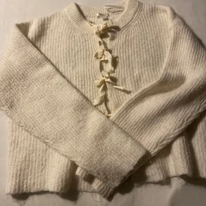 Vit kofta med rosetter från Gina Tricot - Superfin vit stickad kofta från Gina Tricot med  rosetter framtill. Säljer för den inte andvänds💕