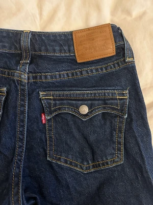 Levis noughties bootcut jeans - Levis bootcut jeans i modellen ”noughties bootcut” stängbara bakfickor med knapp. Slitagelängst ner på benen bak annars felfria. Nypris 1500kr. storlek 28
