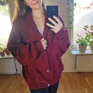 Vinröd kofta med gröna & blå ränder - Urgosig vinröd vintertröja med gröna och blå ränder. Denna har agerat jultröja två år i rad. Nu i flyttstäd får den vandra vidare och förgylla någon annans vinter ❤️ Ballongärmar och mudd i ärmarna 🎈