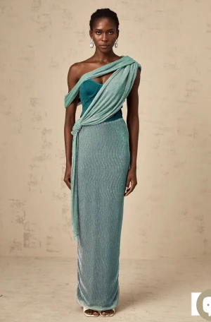 Turkos långklänning med omlott och slits - Säljer en elegant turkos långklänning med glittrigt tyg och omlott-detalj över axeln. Klänningen har en axelbandslös design med draperad effekt och knyt i midjan. Materialet är glansigt och skimrande, och baktill finns en slits för extra rörelsefrihet. Klänning från miss rosier storlek xs helt ny med prislapp. Nypris 1800kr.