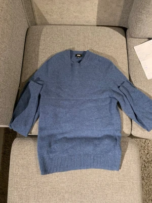 Blå stickad tröja - Pris kan diskuteras!Snygg blå stickad tröja från H&M med rund hals och ribbade muddar vid ärmslut och nederkant. Tröjan har en klassisk passform och är perfekt för dig som gillar enkel och stilren design. Materialet är mjukt och skönt mot huden.