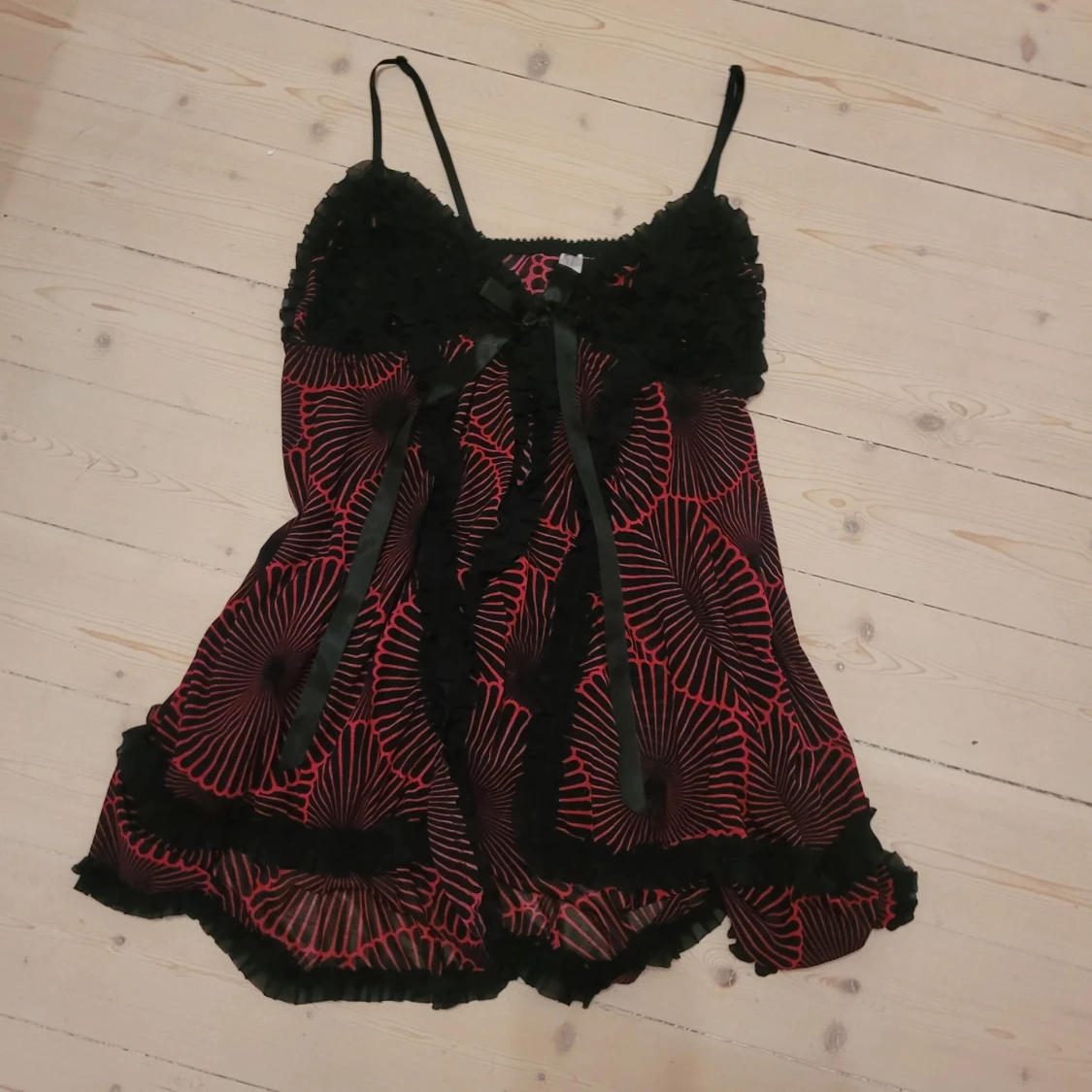 Svart och röd blommig linnetopp med rosett