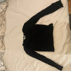 Svart långärmad topp med volang - Svart långärmad topp från H&M med volangdetaljer vid halsringningen och lätt rynk framtill. Tunn och mjuk i materialet, perfekt för lager-på-lager. Enkel och stilren design som funkar till många outfits. Säljer pga att den inte kommer till användning. Pris kan diskuteras 💞