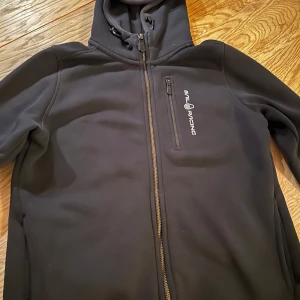 Svart hoodie från Sail Racing - Svart hoodie från Sail Racing. Perfekt för kyliga dagar och snygg till jeans. Storlek 160. Fler bilder kan skickas. Pris går att diskutera. 