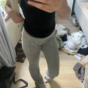 Grå mjukisbyxor med fickor från juicy couture  - Grå mjukisbyxor från juicy couture. De har två fickor framtill och två fickor bak. Byxorna har utsvängda ben och är gjorda i ett mjukt och bekvämt material. Snygg och enkel design som passar till allt. Men de har en missfärgning nedertill. Nypris: 1200kr