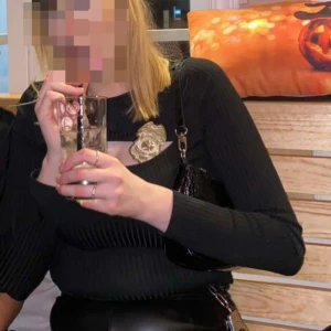 Svart ribbad långärmad topp med cut out - Säljer en svart ribbad långärmad topp med snygg cut out-detalj över bröstet. Tröjan är figurnära och har en modern look som passar perfekt till skinnbyxor eller kjol. Materialet är stretchigt och bekvämt, vilket gör den enkel att styla till olika outfits. Tjejen på bilden är 180 cm.