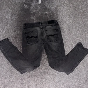 Svarta skinny jeans från Nudie Jeans - Säljer ett par grå jeans från Nudie Jeans i storlek W30 L32. Jeansen har tecken på användning men är i fint skick.