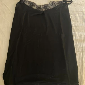 Svart silkes linnetopp med spetsdetalj - Bra skick, st S (säljer för den inte kommer till användning)