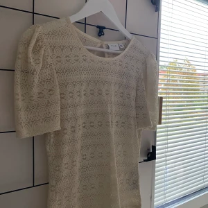 Beige spetsblus från Vila - Säljer en superfin beige spetsblus från Vila med korta puffärmar och rund halsringning. Nästintill aldrig använd därför säljs den! Storlek M men är som S, bara att skriva om frågor eller fler bilder💕
