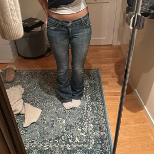 Bootcut jeans från 7 For All Mankind - Snygga blå bootcut jeans från 7 For All Mankind med låg midja. Innerbenslängd 78cm midjemått 37cm rakt över