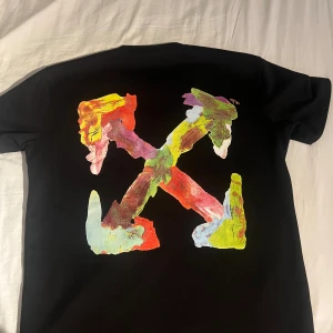 Svarta Off-White set med färgtryck - Säljer ett par svart set från Off-White med elastisk midja och snörning. På framsidan finns ett coolt färgtryck i grönt och gult samt Off-White-loggan. Materialet känns mjukt och är troligen bomull, perfekt för chill dagar.