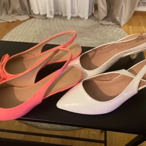 Pumps i rosa och vitt - Två par snygga pumps, ett par i  neonrosa med rosett , och ett par i vit med låg klack. Säljer den för 500kr styck,för dig som gillar att sticka ut med färg och stil😄