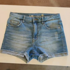 Blå jeansshorts - Blå jeansshorts från LAB Industries. Inte mycket använda, men har en liten fläck baktill. Syns inte mycket dock (bild 4 är inzoomat foto på fläcken).