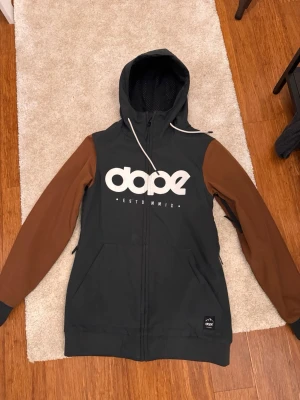 Svart brun skid/snowboard jacka från Dope - Snygg dope jacka i storlek xs, använd ett fåtal gånger bara i skidbacken. Är snygg både till snowboard åkare och skidåkare.