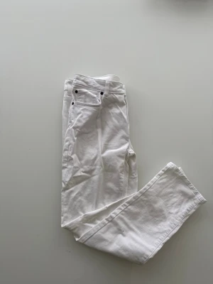 Vita jeans från Dressmann Regular Fit - Säljer ett par fräscha vita jeans från Dressmann i modellen Regular Fit. Klassisk femficksdesign med svarta knappar och bälteshällor. Perfekta för en clean och stilren look. Materialet är bomull med lite stretch för extra komfort.