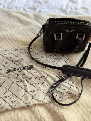 Svart miniväska Zadig & Voltaire - Cool svart miniväska i läder från Zadig & Voltaire med silverfärgade detaljer, dubbla handtag och avtagbar axelrem!!!👏👏🥰🥰🥰🥰