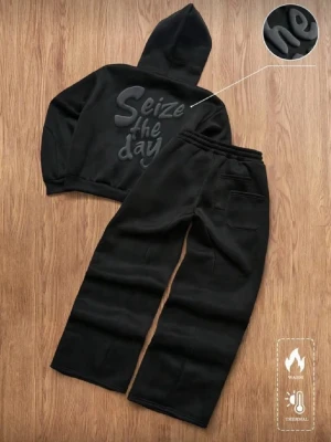 Svart loungewear-set med hoodie - Mysigt svart loungewear-set med hoodie och byxor. Hoodien har texten 'Seize the day' i upphöjt material på ryggen. Byxorna har resår i midjan och fickor. Perfekt för chill dagar hemma. Tjockt och värmande material.