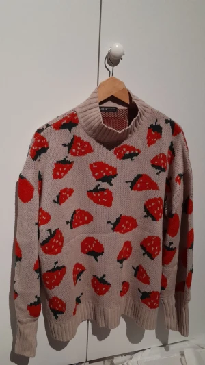 Tröja med jordgubbar - En stickad oversize tröja med jordgubbar.