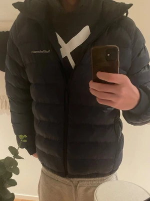 Peak performance jacka  - Säljer en svart pufferjacka med klassisk quiltad design och dragkedja framtill. Jackan har en stilren look och är perfekt för kalla vinterdagar. Passar dig som vill ha en enkel men snygg vinterjacka.