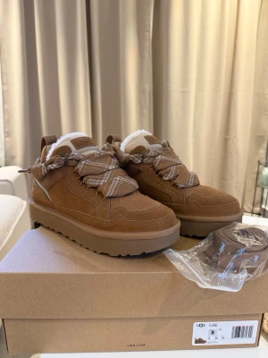 Bruna sneakers från UGG med foder - Säljer ett par bruna sneakers från UGG i mocka med tjocka, mönstrade snören och fluffigt vitt foder på insidan. 1 950:- Endast använda 1 gång 