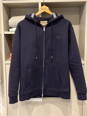 Mörkblå zip hoodie från Burberry - Säljer denna riktigt fina o sällsynta ziphoodien från Burberry | Storlek S | Mått📏: ca 69 längd o 46 axel till axel | Tröjan är dubbeldragkedjad där det står ”burberry” på | Vid fler frågor hör gärna av er!🏌️