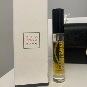 Profumum Roma Dulcis in Fundo  - Exklusiv parfym från Profumum  Roma i doften Dulcis in Fundo. Flaskan är smal och genomskinlig med svart lock och guldfärgad vätska. Kommer i en stilren vit kartong med märkets logga. Tillverkad i Italien och perfekt för dig som gillar lyxiga parfymer. 18 ml flaska, kvarstående på bilden! 