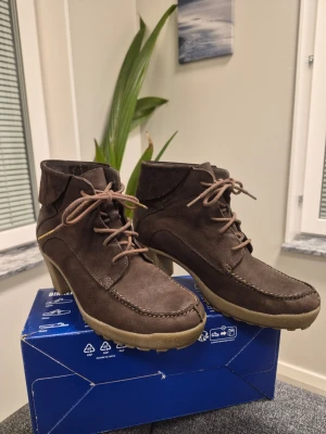 Camel Active Bruna mockastövletter med klack 39 - Snygga bruna stövletter i mocka med snörning och kraftig klack. Skorna har en uppvikt kant upptill och grov sula i beige gummi. Perfekta för dig som vill ha en cool och trendig look med lite höjd. Obetydligt använda 