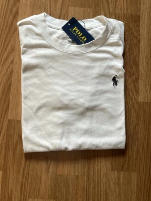 Vit t-shirt från Polo - Klassisk vit t-shirt från Polo för 149 kr !! Helt ny kom med frågor den är m men sitter som s så lite där i mellan👍😅