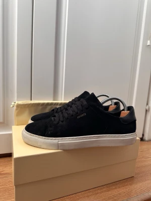 Svarta sneakers Axel Arigato - Läckra skor från Axel Arigato. Stilren vit sula och svart mocka ovanpå. Passar till nästan allt. Skorna är väl omhändertagna. Låda och påse ingår i köp. 