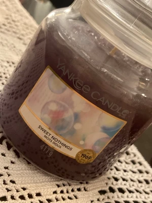 Yankee Candle Sweet Nothings  - Säljer ett doftljus från Yankee Candles i den mycket populära doften Sweet Nothing för 300kr. Storleken är  medium (411g) med en brinntid på 65-75h. Sweet Nothings beskrivs som en mjuk, varm och lätt blommig doft med inslag av cyklamen, lotusblomma, vanilj, pudrig mysk och bärnsten. Ej använt.   