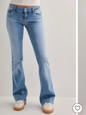 Ljusblå bootcut jeans från Only - Säljer ett par ljusblå bootcut jeans från Only med klassisk femficksdesign och lågmidja. Jeansen har en snygg utsvängd passform och är tillverkade i mjuk denim med stretch för extra komfort. 