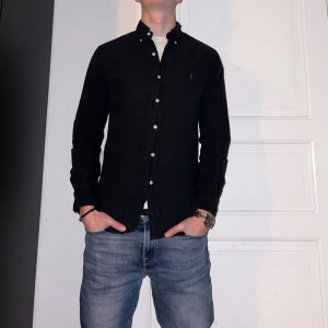 Svart skjorta från Ralph Lauren  - Svart skjorta från Ralph Lauren i storlek S.  Fint skick till ett bra pris. Nypris: 1995kr. Mitt pris: 349kr. Vid frågor eller funderingar, tveka inte att höra av dig.
