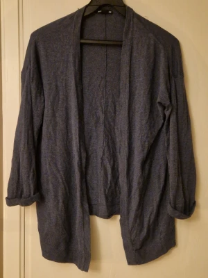 Mörkgrå/blå kofta från H&M Basic - Enkel och mjuk mörkgrå/blå kofta från H&M Basic. Koftan har öppen front utan knappar, långa ärmar som kan vikas upp och en avslappnad passform. Ingen storlekstagg men uppskattas till M. Hund finns i hemmet. Kolla in mina andra annonser för samfrakt! 