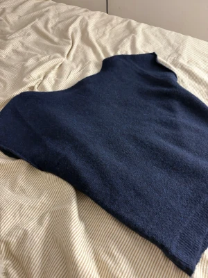 Mörkblå stickad väst från Nelly - Fick i julklapp men den var för stor så därför väljer jag att sälja den. Den är inte använd har bara testat den på. Om ni vill se hur den sitter på så får ni skriva.