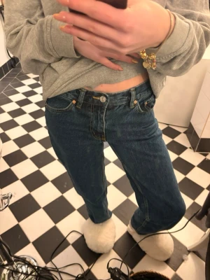 Gina blå jeans straight fit - Jeans från Gina i mörkblå denim med raka ben och normal passform. Liknar Levi's 501. Byxorna har fem fickor, synliga nitar och gylf med knapp. Perfekta för dig som gillar en tidlös och avslappnad look.