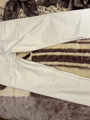 Vita jeansbyxor från Gemma Denim W28 - Säljer ett par stilrena vita jeansbyxor från Gemma Denim i storlek W28. Byxorna har klassisk femficksdesign och raka ben. Perfekta för dig som vill ha en clean och fräsch look. Materialet är jeans och färgen är helt vit.