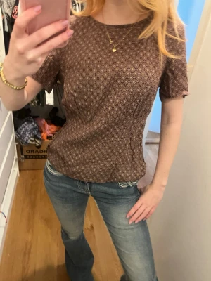 Brun T-shirt med fin passform  - Brun tröja med fin passform då den går inåt vid midjan. 