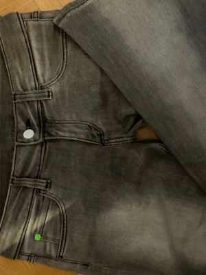 Grå lågmidjade bootcut Cheap Monday jeans - Säljer ett par grå jeans från Cheap Monday i storlek 31/34. Jeansen har en klassisk femficksmodell, lågmidjade bootcut och en snygg tvättad look. Perfekta till en avslappnad stil.