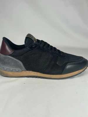 Valentino Rockrunners - Svarta Valentino Garavani Rockrunners sneakers med cool mix av mocka, mesh och skinn. Snygga detaljer. Storlek 42,5. Nypris ca 8000 kr