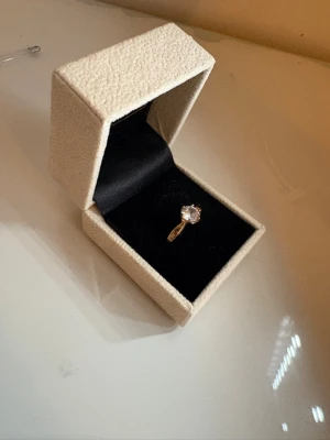 Guldring med diamant - Bilderna visar en guldfärgad ring med en stor klar diamant av kubisk zirkonia . Guldpläterad och gjort av silver. Alldeles för stor på mig därav säljer jag vidare den. Asken tillkommer! Nypris 599kr. 