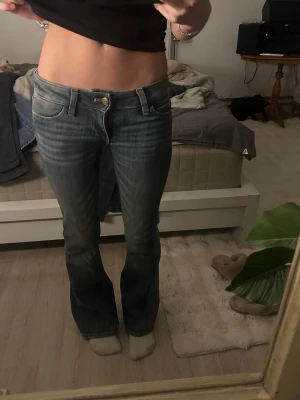 Lågmidjade bootcut jeans från weekday  - Säljer ett par blå lågmidjade bootcut jeans med snygg slitning från weekday. Jeansen har en lätt utsvängd passform nedtill och är super sköna. (Väldig stretchiga) jeansen passar super på mig som ungefär är 161cm ich har bara använts vid fåtal tillfällen. Skriv till mig vid intresse eller om ni har någon fråga💞