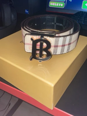 Burberry bälte herr - Burberry bälte i otroligt bra skick. Nästan helt oanvänt. 105 cm lång. Det är reversible och går att få i svart också. Skickas inom 24 timmar efter köp!