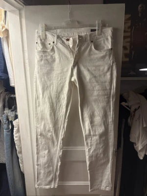 Vita jeansbyxor 32/32 Oscar Jacobson - Säljer ett par vita jeansbyxor i klassisk rak modell. De är tillverkade i bomull och har en clean look som passar till många olika stilar och perfekta för sommaren. Storlek 32/32. Bara o skriva om funderingar med storlek osv. Pris kan diskuteras.