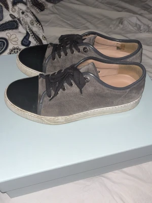 Lanvin grå mocka sneakers med svart tå - Lanvin sneakers i grå färg. Digitalt kvitto samt låda ingår. Storlek 41 men passar 42-42,5