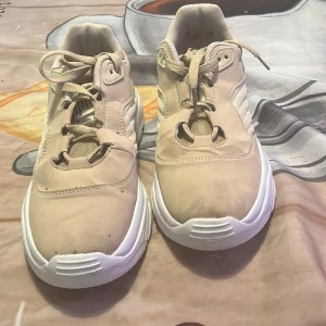 Chunky beige sneakers EU 40 - Chunky sneakers i beige med vit tjock sula och snörning. Ovandelen är en mix av syntet och mesh för extra komfort och cool look. Rund tå och platt sula ger en avslappnad vibe. Perfekt för dig som gillar streetstyle och chunky siluetter.