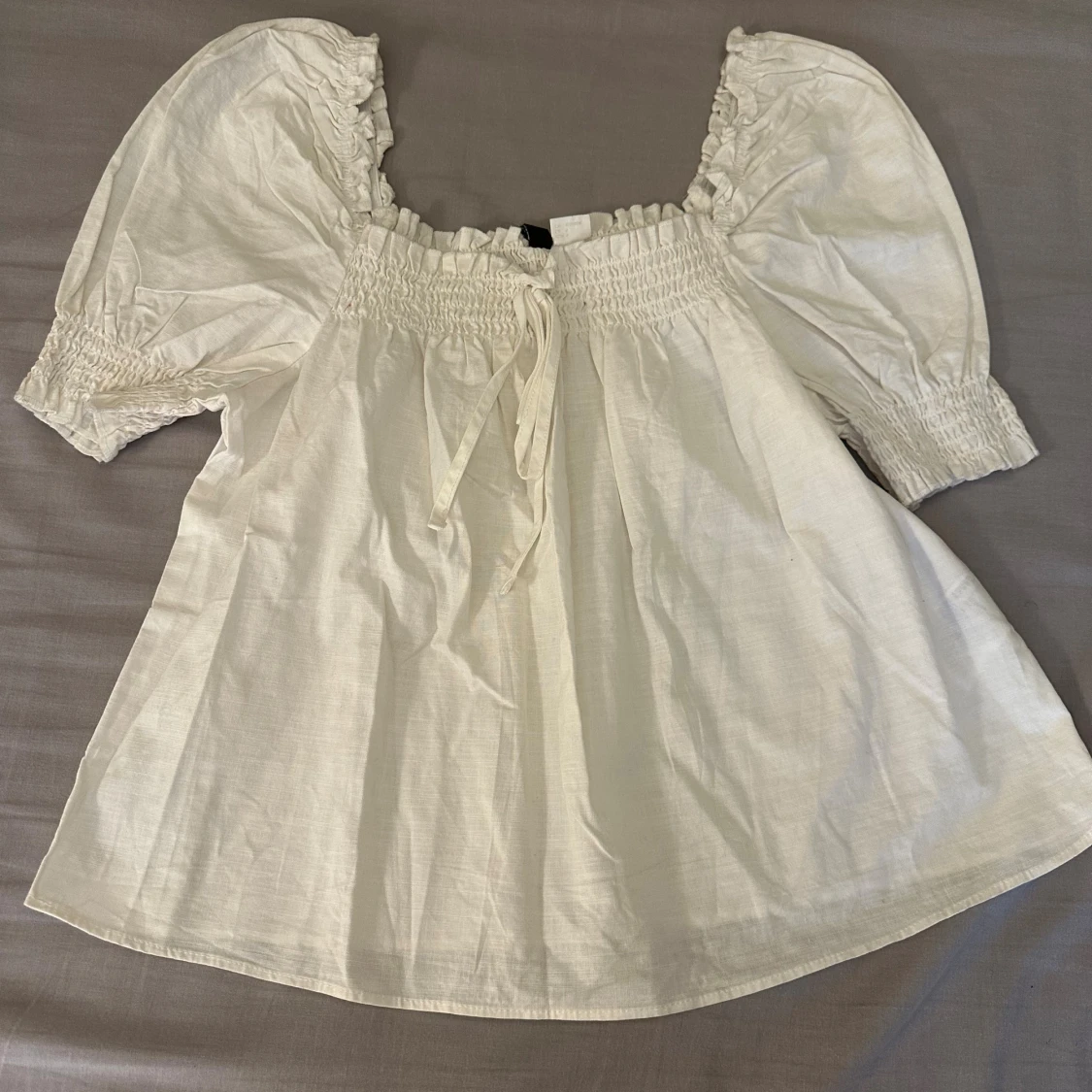 Vit blus med puffärmar och knyt