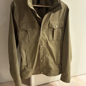 Jacka från J.Lindeberg  - Hej! Säljer ny en snygg olivgrön field jacket från J.Lindeberg, jackan är i ny skick, inga defekter. Storlek S. Pris kan diskuteras🚨För fler frågor eller bilder kom dm🚨