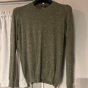 Grön stickad tröja Oscar Jacobson - Snygg grön stickad tröja från Oscar Jacobson, tillverkad i Italien. Tröjan har rund hals och långa ärmar med ribbade muddar vid ärmslut och nederkant. Perfekt för dig som gillar stilrena och klassiska plagg med en modern touch. Pris kan diskuteras!
