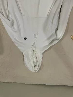 Vit hoodie från Nike med snörning - Säljer en clean vit hoodie från Nike i storlek L. Tröjan har huva med snörning och ett svart Nike-logga broderat på bröstet. Materialet är mjuk bomull och polyester, perfekt för chill dagar. Långärmad och loose fit för skön vibe. Börjar bli lite gul runt halsen inuti men påverkar ingenting