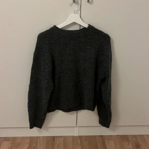 Mörkgrå stickad tröja från H&M XS - Mysig mörkgrå stickad tröja från H&M i storlek XS. Tröjan har en klassisk rund halsringning och långa ärmar. Perfekt för lager-på-lager och chill dagar. Enkel och stilren design som funkar till det mesta.